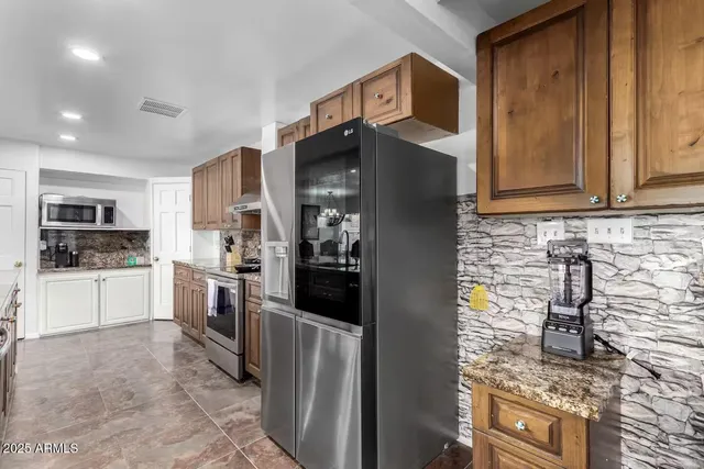 a kitchen with stainless steel appliances granite countertop sink stove and refrigerator
