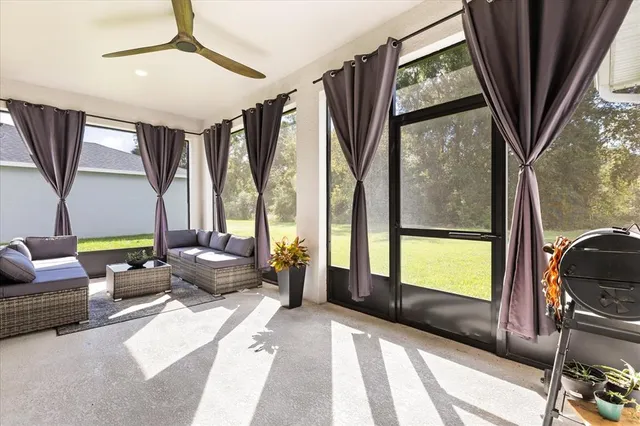 a living room with furniture a large window with outer view and couch