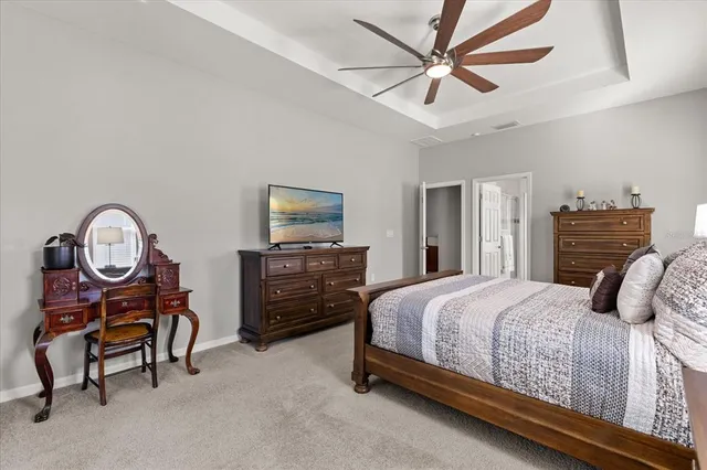 a bedroom with a bed a chandelier and a television