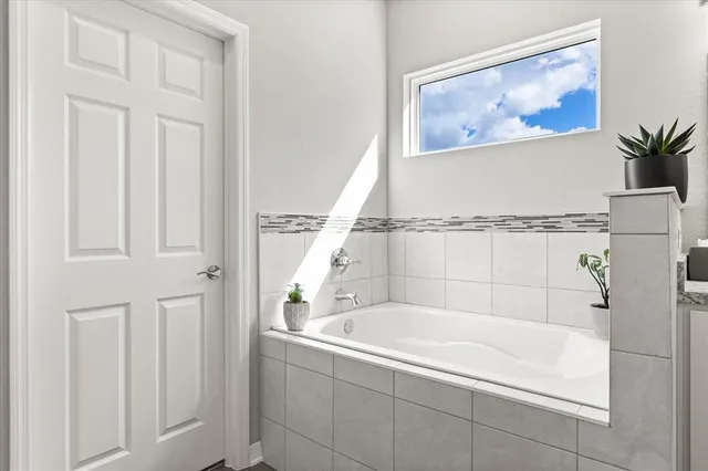 a white bath tub sitting next to a small window
