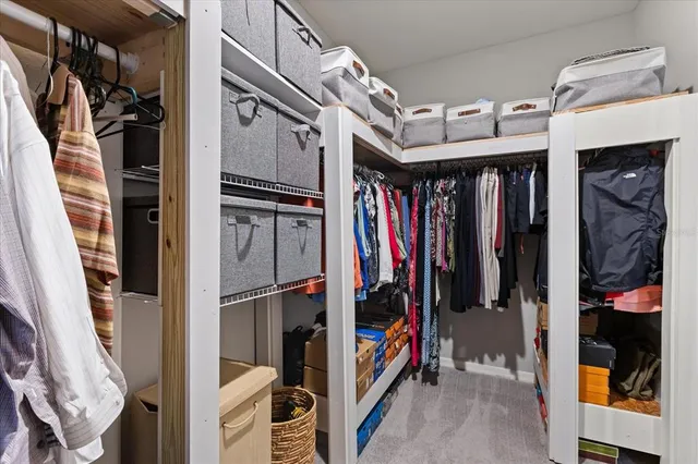 a view of walk in closet with clothes and shoes