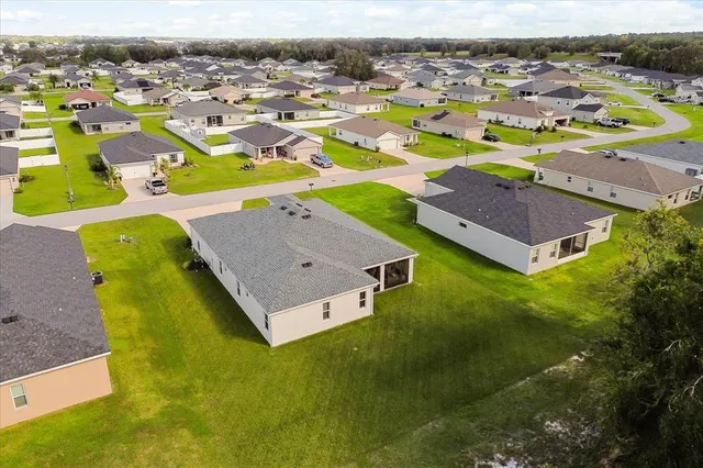 an aerial view of residential houses with outdoor space and swimming pool