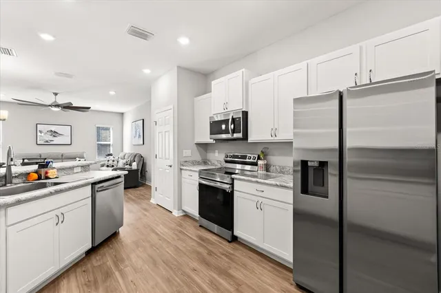 a kitchen with stainless steel appliances granite countertop a refrigerator a stove top oven a sink and dishwasher