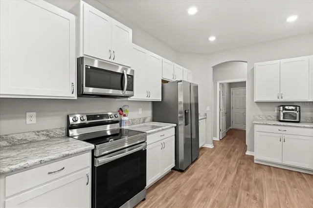 a kitchen with a sink stove top oven and refrigerator