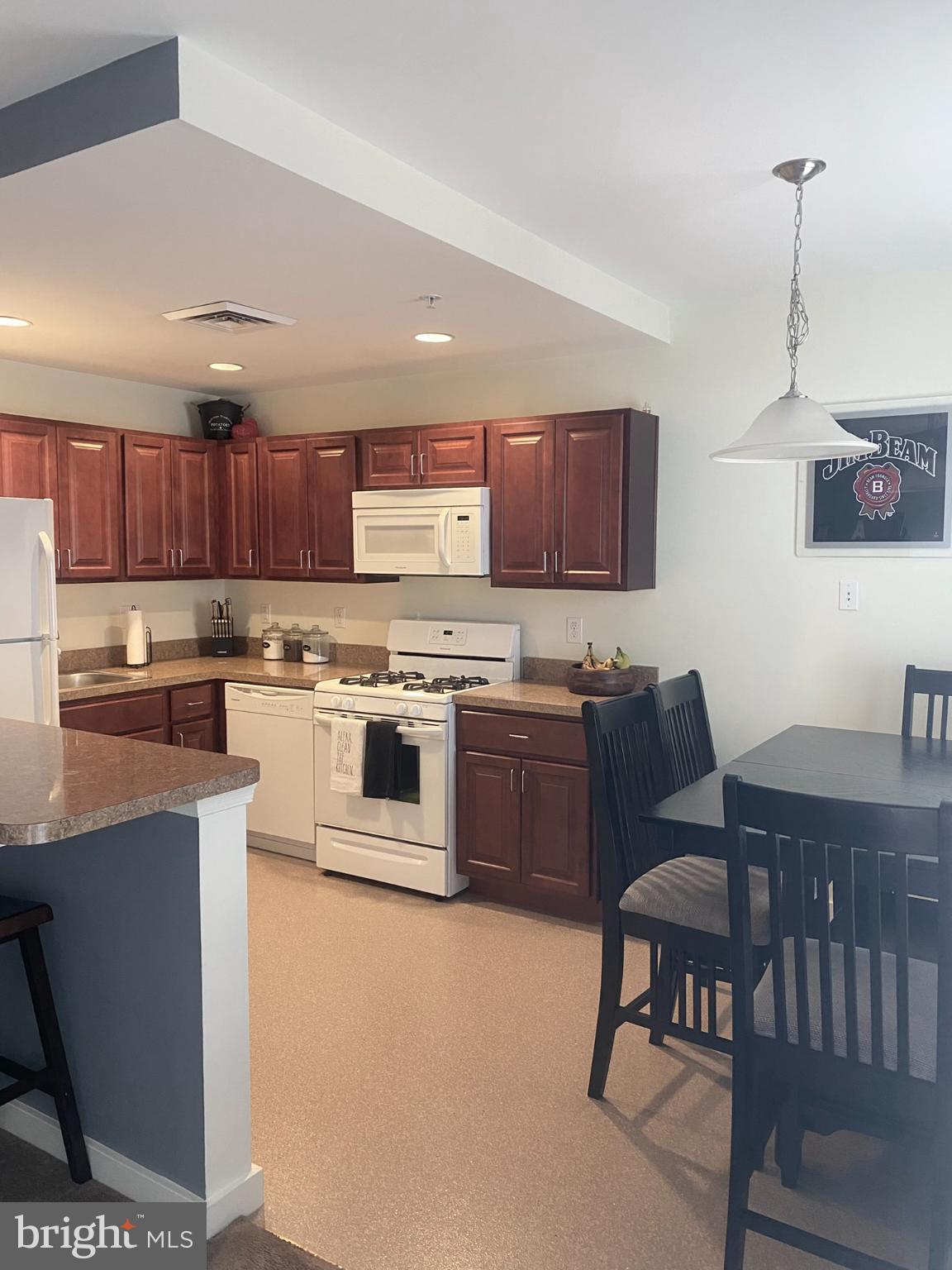 1600 Church Road, Unit B213 Wyncote, PA 19095 - Photo 2 of 25 a kitchen with stainless steel appliances kitchen island granite countertop a stove a sink a microwave and a refrigerator