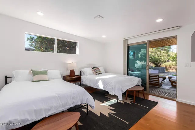 a bedroom with two beds and a potted plant