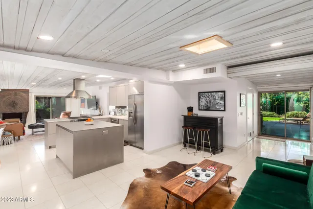 a living room with furniture a large window with kitchen view