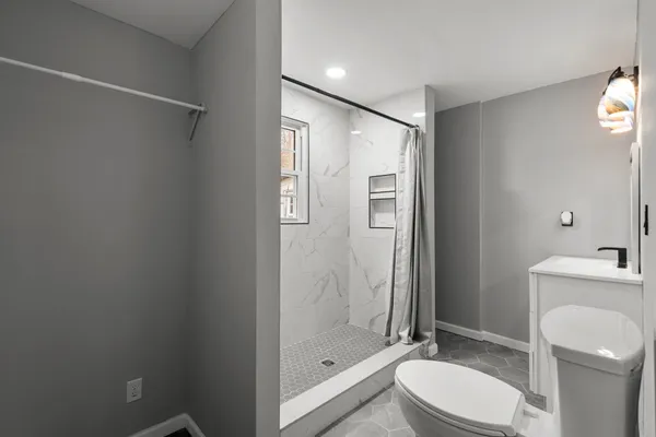a bathroom with a shower a toilet and sink
