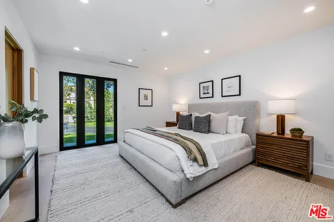 a spacious bedroom with a bed and a potted plant