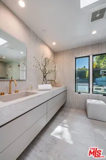 a spacious bathroom with a tub sink and mirror