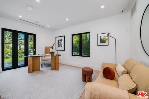 a bedroom with furniture and a large window