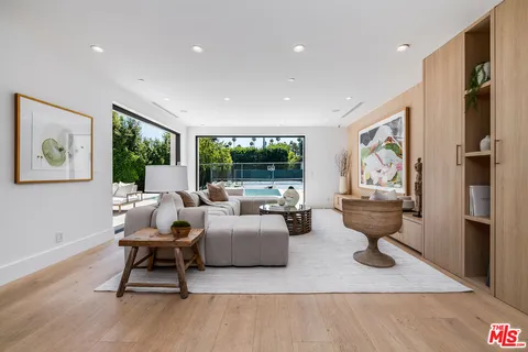 a living room with fireplace furniture and a large window