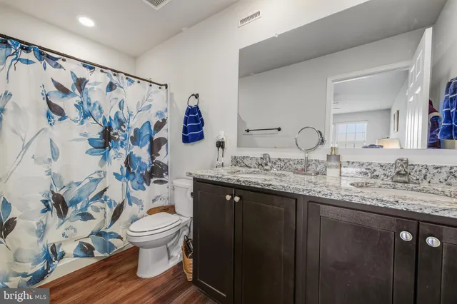 a bathroom with a granite countertop toilet sink and mirror