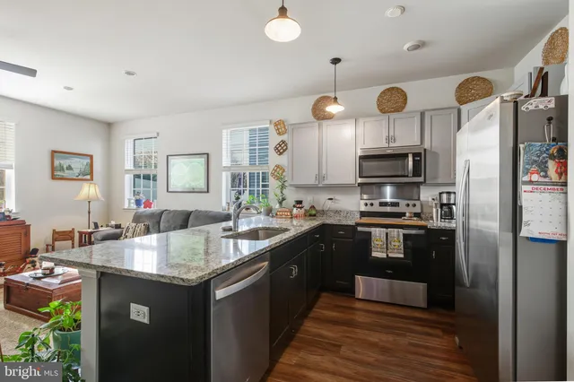 a kitchen with granite countertop a sink cabinets and stainless steel appliances