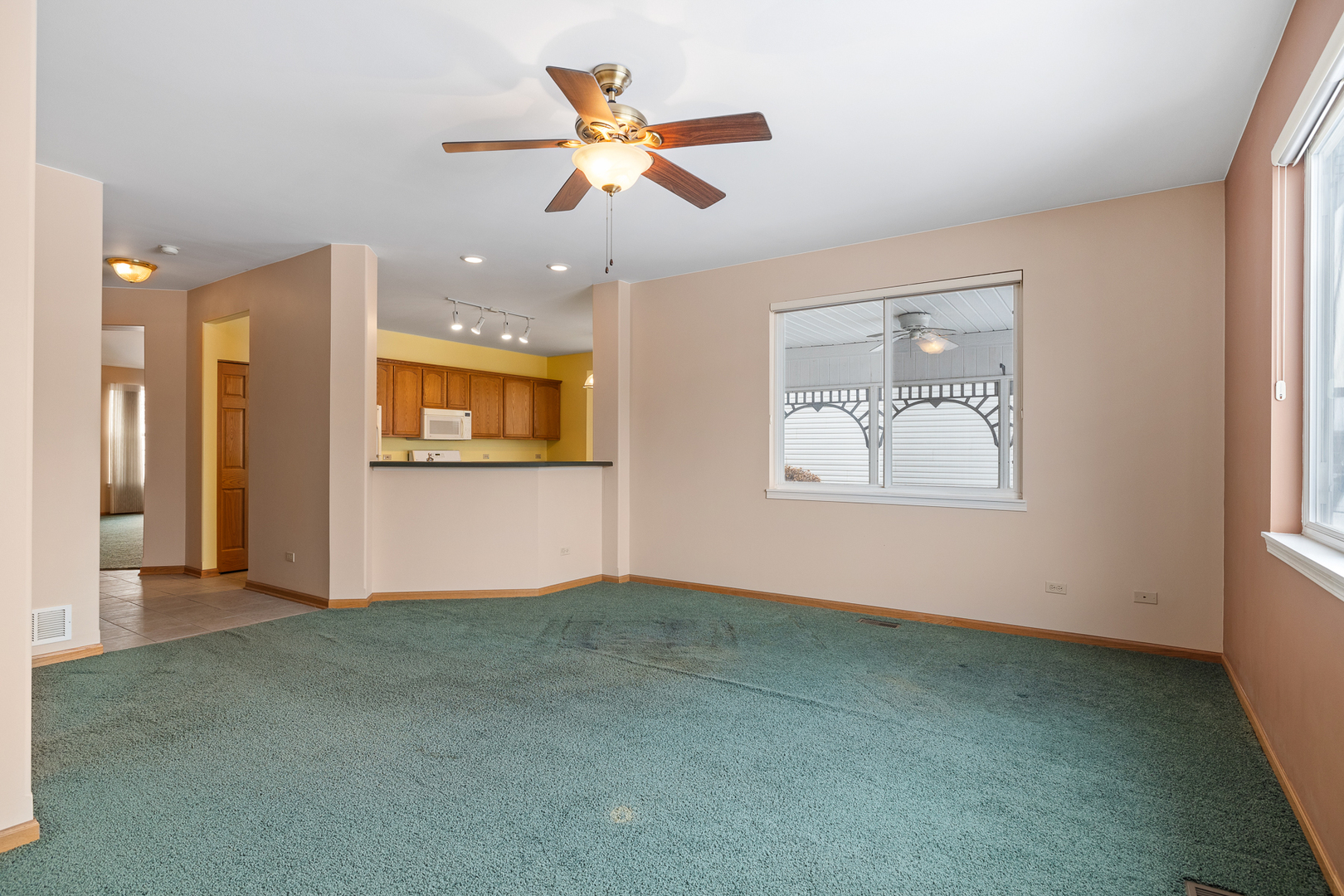631 Saugatuk Circle Romeoville, IL 60446 - Photo 7 of 22 an empty room with ceiling fan and windows