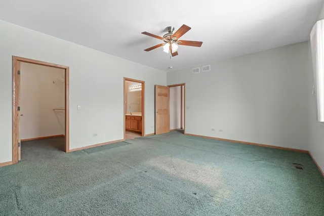 an empty room with ceiling fan and window