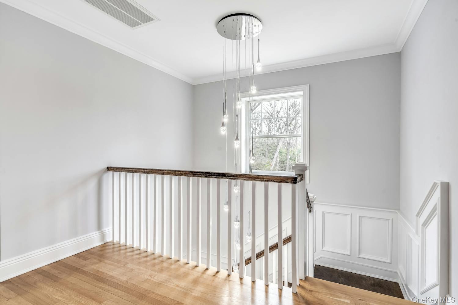 539 Split Rock Road Syosset, NY 11791 - Photo 8 of 40 Stairs featuring crown molding, baseboards, visible vents, and wood finished floors