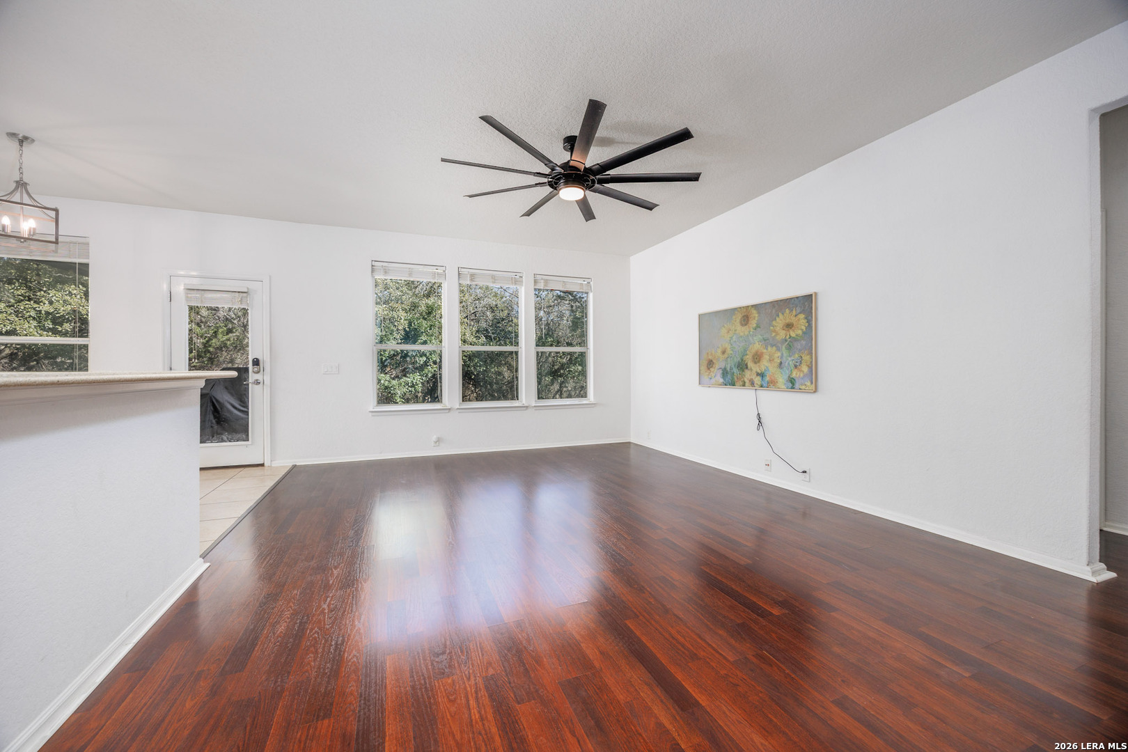 4702 Thomas Rusk San Antonio, TX 78253 - Photo 3 of 18 an empty room with wooden floor a ceiling fan and windows