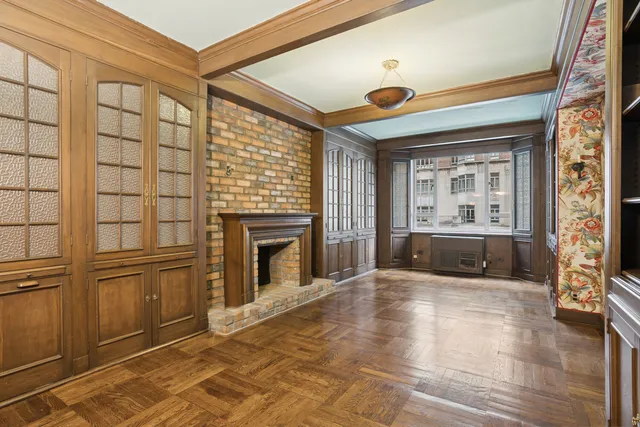 a view of an empty room with a fireplace and a window
