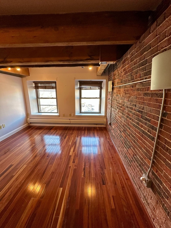 57 Fulton Street, Unit 11 Boston, MA 02109 - Photo 3 of 5 a view of empty room with wooden floor and fan