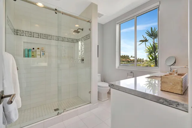a bathroom with a granite countertop sink a toilet and mirror