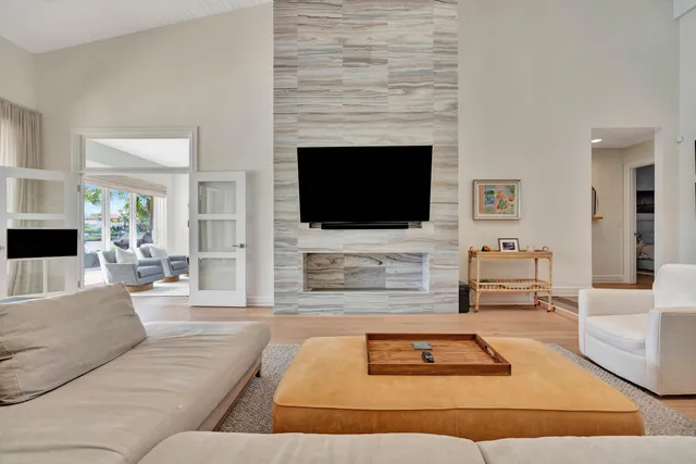 a living room with furniture wooden floor and a large window