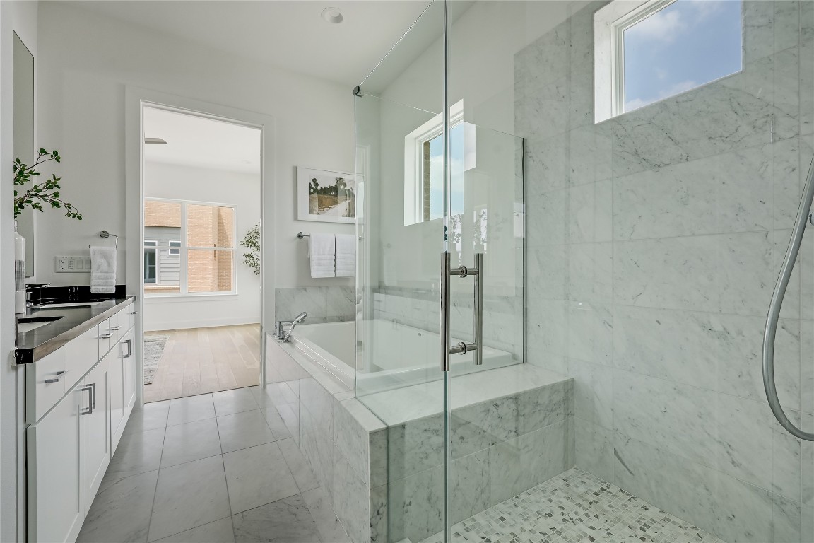 2805 McCurdy Street, Unit 19 Austin, TX 78723 - Photo 18 of 39 Soak off the day;s stress in the large 9' soaking tub and enjoy a spacious frameless glass walk-in shower, both of which are surrounded in elegant tile backsplash.