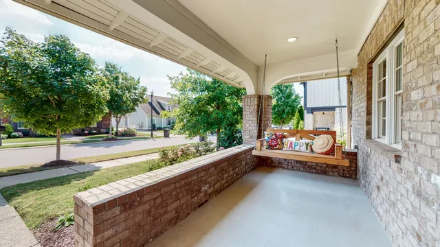 a kitchen with stainless steel appliances granite countertop a refrigerator a stove a sink dishwasher a refrigerator and a dining table with wooden floor