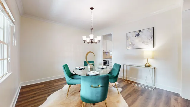 a dining room with furniture a chandelier and wooden floor