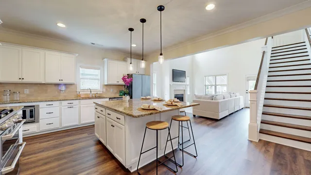 a kitchen with granite countertop a dining table chairs and white cabinets