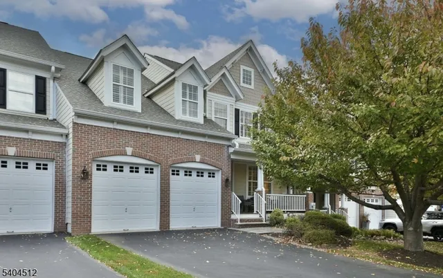 a front view of a house with a tree