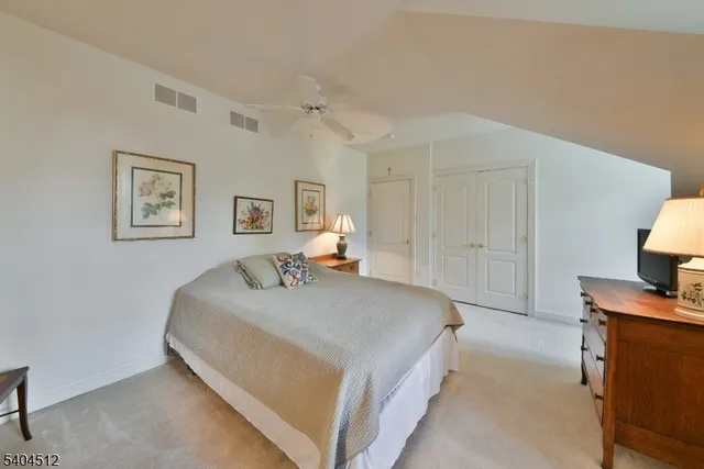 a bedroom with a bed and a lamp on dresser