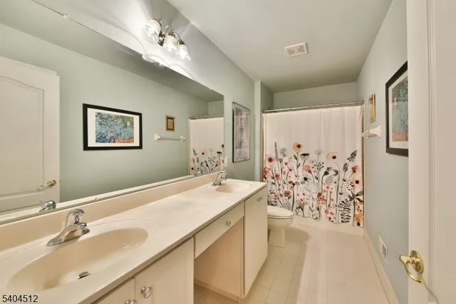 a bathroom with a double vanity sink mirror and shower