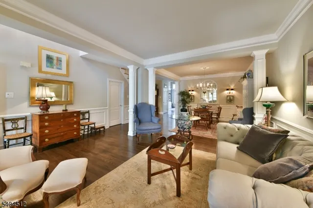 a living room with furniture kitchen view and a wooden floor