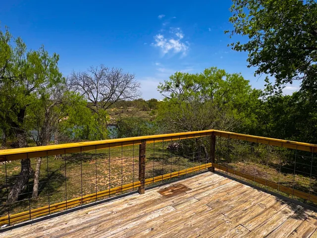 a view of balcony with wooden floor and fence