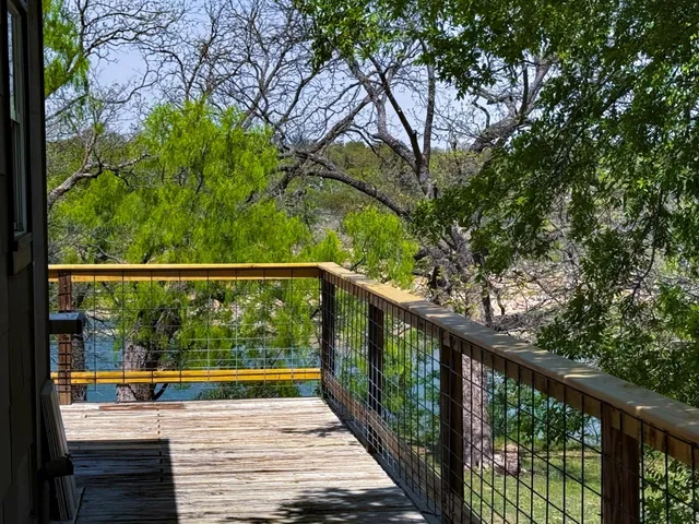 a view of balcony with wooden floor and fence