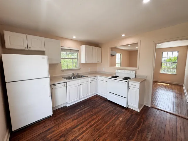 a kitchen with wooden floors and white appliances