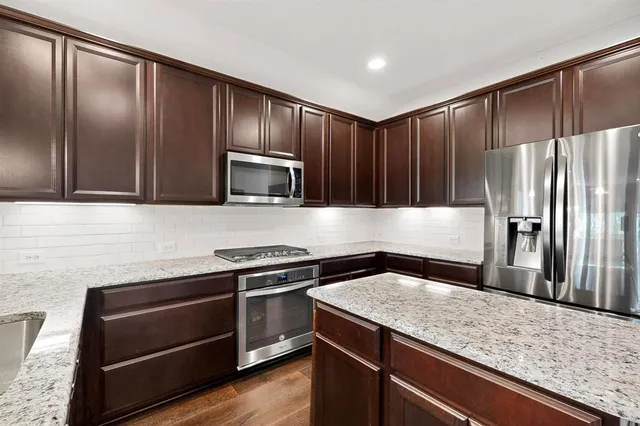 a kitchen with granite countertop stainless steel appliances cabinets a sink and a counter space