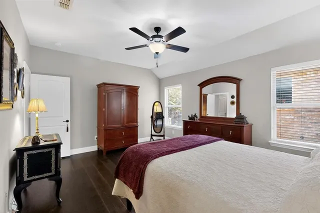 a bedroom with a bed and dresser with mirror