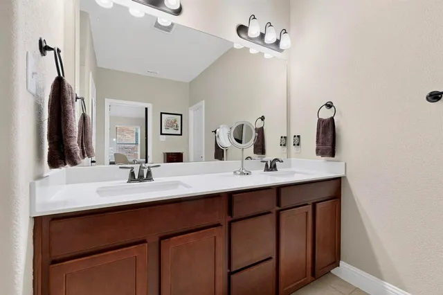 a bathroom with a double vanity sink and a mirror