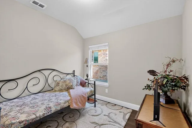 a bedroom with a bed and a potted plant