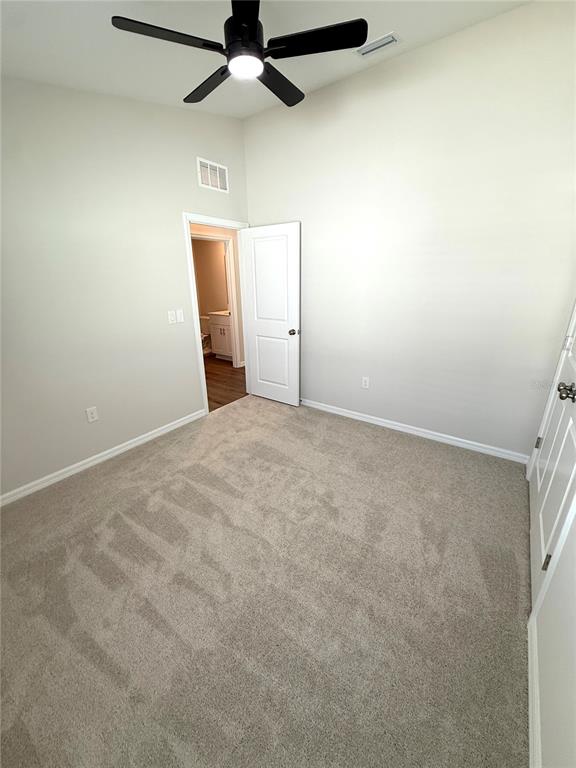 34706 Blossom Fall Path Dade City, FL 33525 - Photo 11 of 27 an empty room with a ceiling fan and carpet
