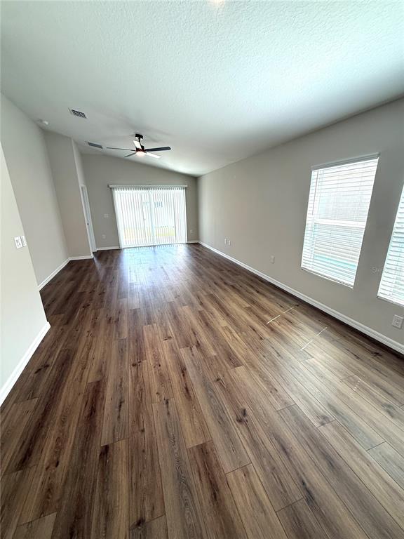 34706 Blossom Fall Path Dade City, FL 33525 - Photo 12 of 27 wooden floor in an empty room with a window