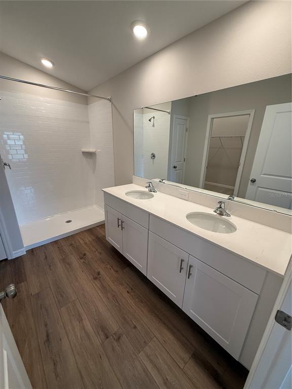 34706 Blossom Fall Path Dade City, FL 33525 - Photo 16 of 27 a bathroom with a double vanity sink and mirror
