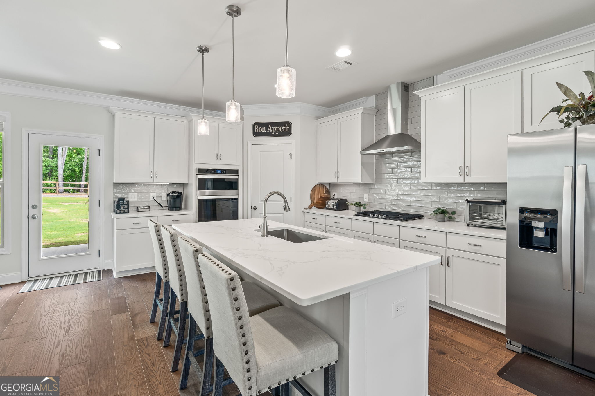 2884 Porches Lane Dacula, GA 30019 - Photo 7 of 41 a kitchen with stainless steel appliances granite countertop a stove a refrigerator a kitchen island a sink and white cabinets with wooden floor