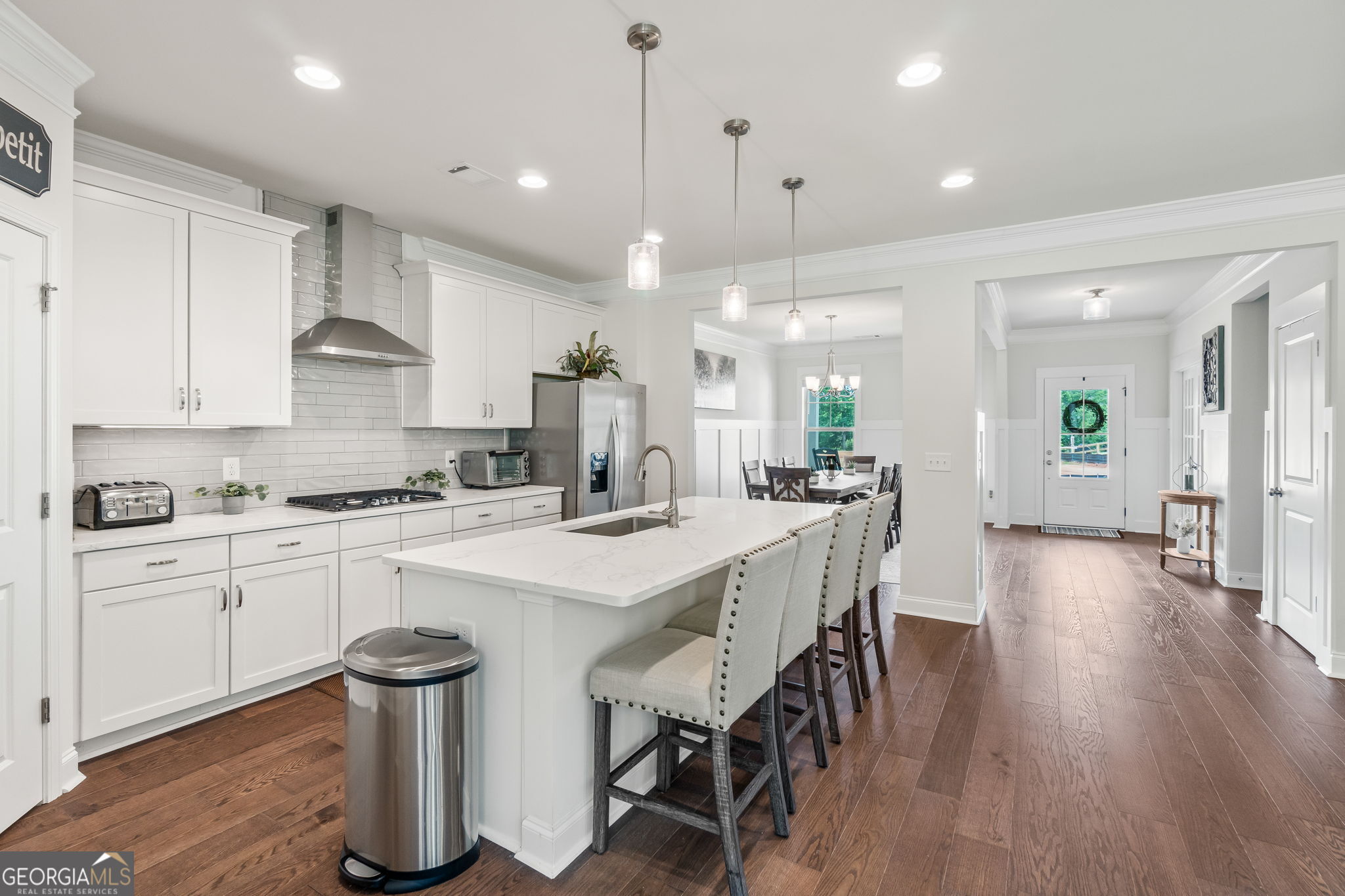 2884 Porches Lane Dacula, GA 30019 - Photo 8 of 41 a kitchen with stainless steel appliances kitchen island granite countertop a stove a sink a refrigerator and white cabinets with wooden floor