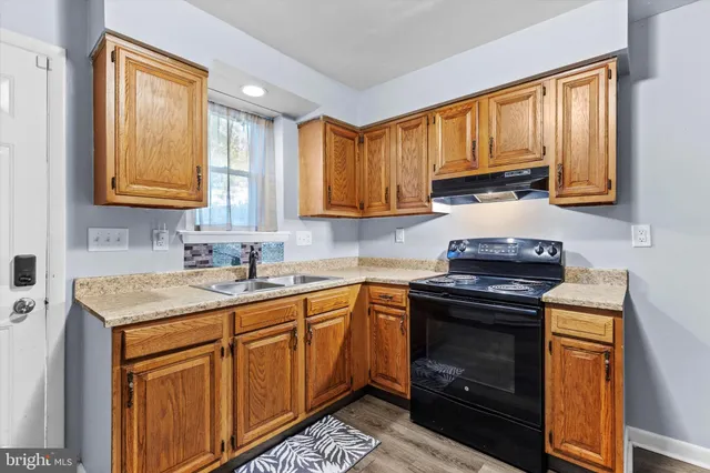 a kitchen with stainless steel appliances granite countertop wooden cabinets sink and a granite counter top