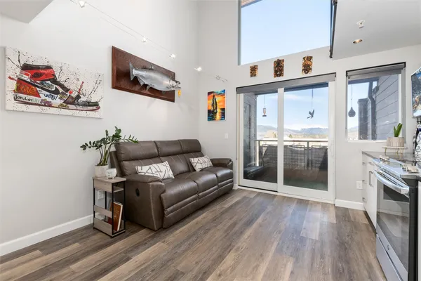 a living room with stainless steel appliances furniture and a kitchen view