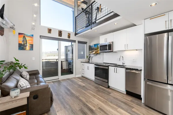 a kitchen with stainless steel appliances a refrigerator sink and wooden floor