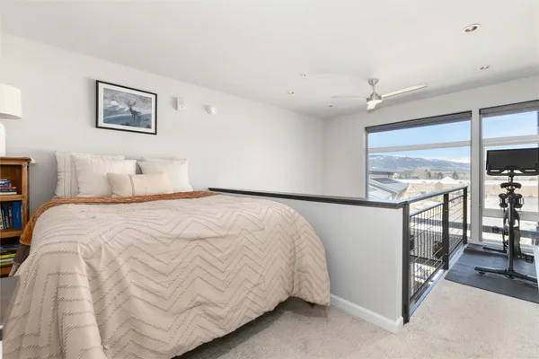 a bedroom with a bed and glass windows